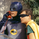 Batman and Robin take a call on a red telephone.